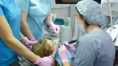 Dişçi ve diş hekimlerinden korkan bir kız. Solucan Yatıştırıcı kullanan doktorlar. Modern prosedürleri olan bir dişçi kliniği. Eller azot oksit anestezi cihazından yüz maskesi tutuyor. 4 bin.