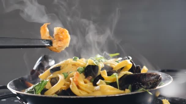 自家製スパゲティ麺パスタでおいしい揚げエビを提供しています。スローモーション。エビ入りの伝統的なシーフードパスタ。蒸気や蒸気が立ち上がる。伝統的なイタリア料理。フルHD — ストック動画