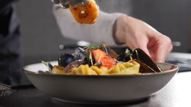 Podáváme lahodné smažené krevety s domácími špagetovými nudlemi těstovin. Zpomal. Dávám smažené krevety do tradičních těstovin z mořských plodů. Pára nebo stoupající pára. Italská kuchyně. Full hd — Stock video