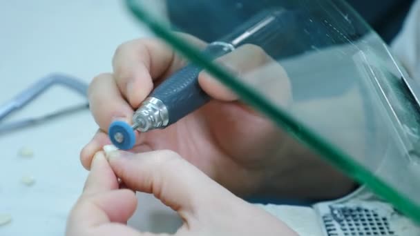 Estomatologia, medicina, restauração. dentista ou técnico dentista mãos segurando ferramenta de handpiece motor e trabalhando com prótese dentária. Técnico dentário trabalhando com coroas de cerâmica. 4 k vídeo — Vídeo de Stock