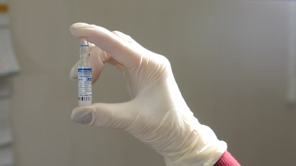 Moscú, Rusia, 10 de febrero de 2021. Ampolla lista con vacuna contra el coronavirus Covid-19 Sputnik V en la mano enguantada. vacunación en Rusia. EpiVacCorona. Fabricación farmacéutica. 4 k vídeo — Vídeo de stock