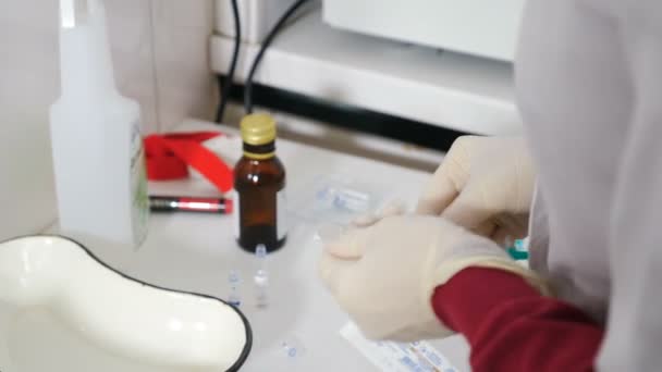 Koruyucu eldivenli bir tıbbi asistan elinde şırıngayla şişeden şırınga 19 Corona virüsü aşısı alıyor ve enjeksiyona hazırlanıyor. Coronavirus bağışıklığı, grip tedavisi aşısı, 4 K video — Stok video