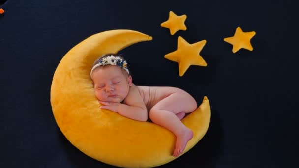 사진 촬영 - 잠 자고, 달 모양 과 별 모양의 노란 부드러운 장난감 위에 포즈를 취하는 모델로서의 어린 아기. 사랑스럽고 귀엽고 감동적 인 10 일된 신생아가 포토 존에서 자고 있습니다. — 비디오