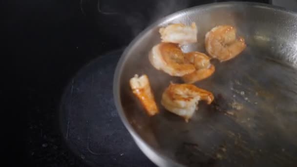 Echando los langostinos sabrosos frescos con las gotas de aceite en la sartén grande metálica. Cocina restaurante de mariscos de lujo. En cámara lenta. Preparación de gambas fritas para ensalada. Cocinar comida. Full hd — Vídeos de Stock