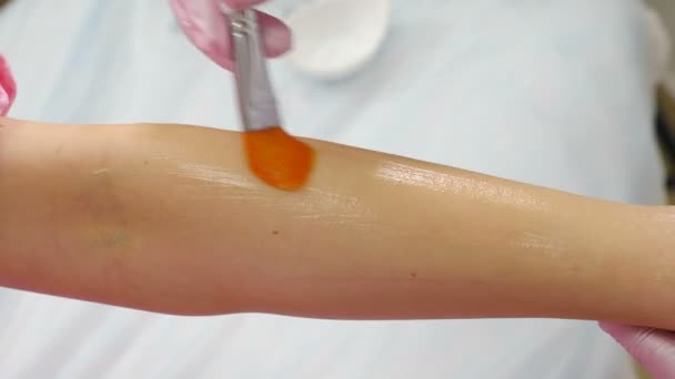 Vrouwelijke cosmetoloog brengt laser ontharing gel op vrouwelijke hand. fotoepilatie, lichaamsverzorging en huidverzorging. Schoonheidsspecialiste in schoonheidssalon. 4 k video — Stockvideo