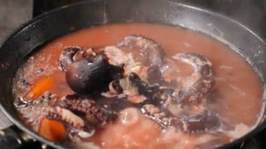 Mutfakta tavada haşlanmış ahtapot. Üst Manzara. Evde ya da restoranda deniz ürünleri pişirmek. Taze ahtapot ve sebze pişirme. Restoran gurmesi deniz ürünleri yemeği hazırlama konsepti. 4 k video