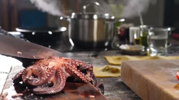 Ο σεφ κόβει βραστό χταπόδι με μαχαίρι. Βραστό κατσαρολάκι και σκεύος στο φόντο. Υγιεινά τρόφιμα και χορτοφαγικά έννοια. Εστιατόριο θαλασσινών. Gourmet 4 k βίντεο — Αρχείο Βίντεο