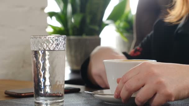 Levenslang in café of restaurant. Zijaanzicht. Vrouwelijke hand met witte koffiekop op tafel. Restaurant straat voedsel levensstijl. coffeeshop, Business lunch, regenachtig weer, gezellige tijd. Vol hd — Stockvideo