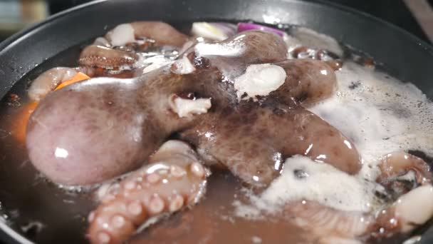 V kuchyni se vaří mořské plody. Vynikající velká chobotnice vařící se na pánvi. Vroucí voda v hrnci. chobotnice se připravuje. Video s jídlem. 4 k video — Stock video