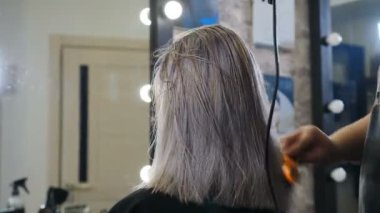 Kadın saçını kestiriyor. Kuaför kuaförle kuaför. Güzellik Kuaförü. Berber dükkanında saç kesimi için saç kesimine hacim katıyor. Berber eller saç kestikten sonra el sallıyor. 4