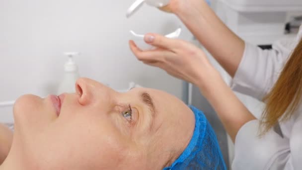 Esteticista espreme máscara facial transparente em tigela de vidro para o procedimento de beleza facial na clínica. Preparação de cara para descascar de cara. Rejuvenescimento a laser e tratamento da pele problemática. 4 k vídeo — Vídeo de Stock