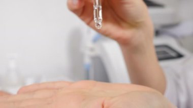 Kadın avucunun üzerine düşen sıvı damlaları, nefes alma terapisi, nefes alma ve rahatlama. Kozmetik uzmanı temizleyici nemlendirici sıvıyı döküyor. Profesyonel cilt bakım ürünleri. 4 bin.
