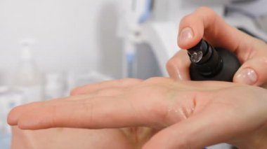 Kadın elleri şeker kutusuna bastırır ve avuç içine sabun jölesi sıkar. Kozmetik uzmanı temizleyici nemlendirici jel döker. Profesyonel cilt bakım ürünleri. Güzellik salonu. Kozmetik sıvısı. 4 k video