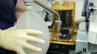 Ameliyat sırasında yapay akciğer havalandırması ve anestezi uzmanı eli. Yapay akciğer havalandırması için modern tıbbi cihazın hareketi. Ameliyat sırasında pulmoflatör. Yaşam ekipmanlarını kurtarıyorum. 4 k video