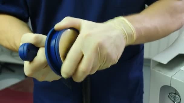 Defibrolator in anesthesia care provider doctor hands Blue medical clothes. First aid. Doctor holding defibrillation electrodes and turninf cap to save children lives. resuscitator at work in clinic — Stock Video