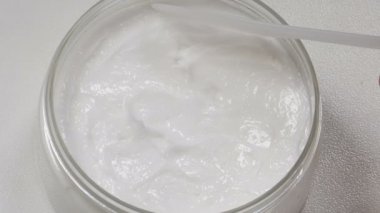 Güzellik, sağlık ve vücut, yüz ve bacaklar için cilt bakımı. Üst Manzara. Güzellik uzmanı spatulayla krema alıyor. Modern kuaförde güzellik prosedürü. Kozmetik kliniğinde cilt bakımı. 4 k video