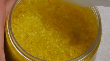 Güzellik uzmanı spatulayla güzellik prosedürü için vücut fırçasını çıkarıyor. Cilt ovalayıcı. Soyma, vücut bakımı. Kozmetik uzmanı, kadın derisine uygulamak için kavanozdan fırça alıyor. Üst Manzara. 4 k video