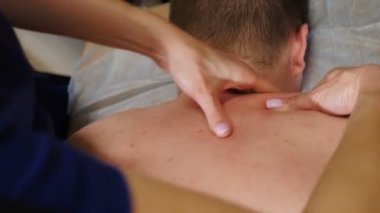 Sağlık hizmeti prosedürü. Erkek sırt masajı yapan bir masör. Doktor terapist masaj masasında yatan erkek hastaya elle masaj yapıyor. Profesyonel masaj. 4 k video