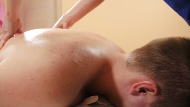 Procedura opieki zdrowotnej. masażysta robi sportowy masaż męskich pleców. Lekarz terapeuta wykonujący ręczny masaż pacjentom leżącym na stole do masażu. Profesjonalny masaż. 4 tys. wideo — Wideo stockowe