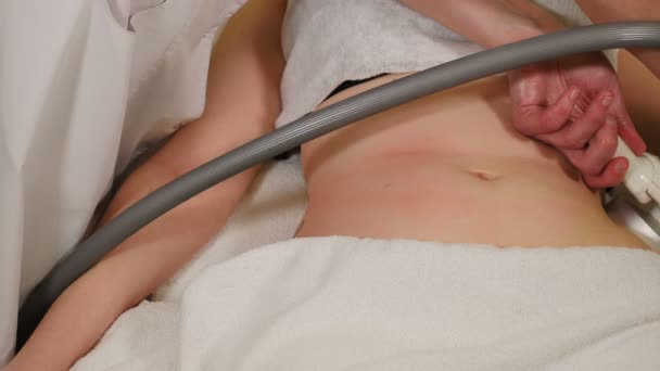 Cosmetóloga profesional haciendo masaje por vacío hardware para paciente joven femenina. Tratamiento anticelulítico de corrección corporal en clínica de belleza. Masaje al vacío de abdomen. 4 k vídeo — Vídeos de Stock