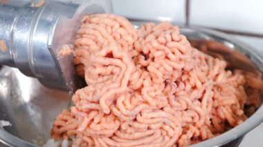 Şef modern gıda imalatında profesyonel kıyma makinesine balık dilimleri koyuyor. Elektrikli kıyma makinesi iş başında. Çiğ et öğütücüsünden çıkan balık dolması. 4 k video