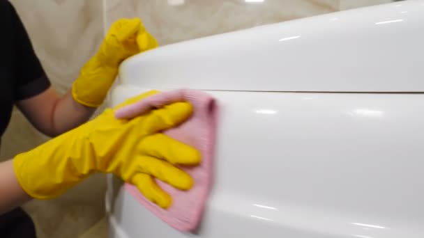 Καμαριέρα ή νοικοκυρά σκουπίζει καλά λευκή επιφάνεια μπάνιου με κουρέλι. Καθαρισμός σε ξενοδοχειακό διαμέρισμα. προσωπικό του ξενοδοχείου καθαρισμού νιπτήρα με καθαριστικό. σκούπισμα μπανιέρα Jacuzzi στο μπάνιο σε κατοικίες — Αρχείο Βίντεο