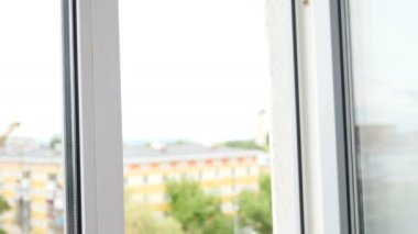 Havalandırma ve havalandırma odası. Otelde temizlik. Eldivenli temizlikçinin pencere kolunu tutup temiz hava girmesi için açtığı yakın çekim görüntüsü. Otel odası ya da konut binası. 4k görüntü