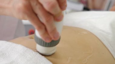 Vücut bakımı konsepti. Rf derisi kadın karnında sıkışıyor. Kozmetoloji prosedürü. Vücut hatları ve selülit azaltımı. Kadın anti-selülit tedavisi görüyor. Güzellik makinesiyle.