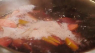 Cooking compot. beverage made of variety fresh berries. Boiling water with berries in saucepan. Rich, red, refreshing drink with bubbles, foam. Making delicious homemade compote. Side view. 4 k video