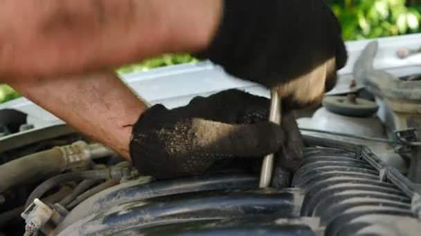 Benzin istasyonunda araba tamir eden eldiven tamircileri. Tamirci, ingiliz anahtarını kullanarak motoru ve araba servisini tamir ediyor. Yeni yedek parça. Onarım servisi. Yakın plan çekim. 4 k video — Stok video