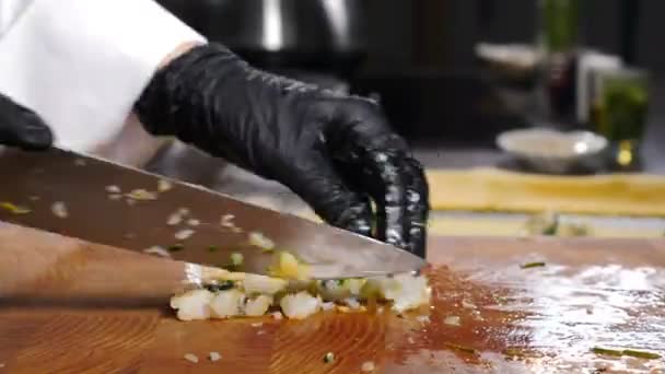 Vařím záběry z jídla. Šéfkuchař v černých rukavicích rychle krájí krevety a mísí je se zelení. Šéf restaurace připravuje pokrmy z mořských plodů. Zdravé ingredience na vaření. Dělám jídlo. 4 k video — Stock video