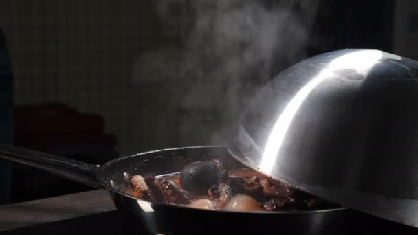 Μαγειρεύοντας χταπόδι βράζοντάς το σε τηγάνι με ατμό να ανεβαίνει σε μαύρο φόντο. Θαλασσινά μαγείρεμα στην κουζίνα εστιατόριο. Υπέροχο μεγάλο χταπόδι που βράζει στο τηγάνι. βραστό νερό. χταπόδι ετοιμάζεται — Αρχείο Βίντεο