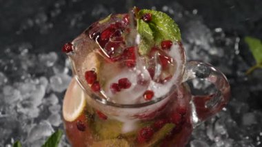 dilimlenmiş kireç, böğürtlen ve buz ile transparet kavanozuna soğuk su dökülüyor. Ağır çekim. Barmen taze yaz kokteyli hazırlıyor. Gece hayatı ve gece kulübü. Tam Hd