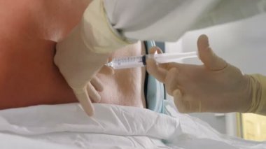 Omurilik anestezisi, epidural anestezi ya da sinir bloğu. Anestezi uzmanı iş başında. Anestezi uzmanı ya da doktor hastanın arkasında epidural iğne tutuyor, sezaryen için hazırlanıyor.