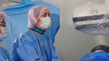 Damar ameliyatı. Doktor anjiyografi makinesiyle endovasküler ameliyat yapıyor. Cerrah rahim fibroid embolizasyonu için kontrast sıvısı kullanıyor. Kardiyo-vasküler muayene. 4k video