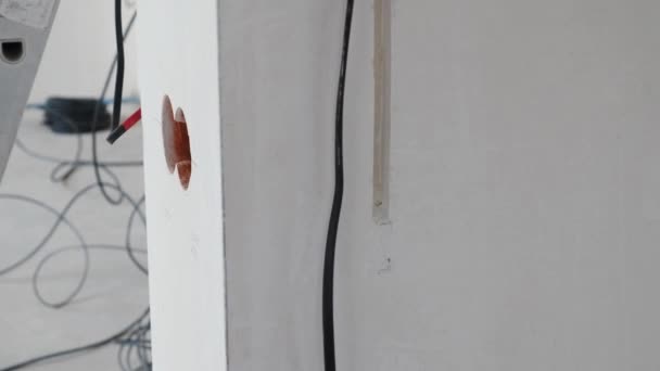 Construction, electricity, safety, household -repair of electrical wiring. Electrical cable system setting. Electrician repairing wires. House improvement and renovation. Electric cable in — Stock Video