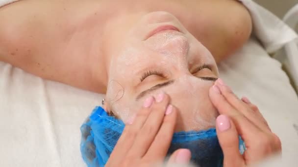 Cosmetologie en schoonheidsconcept. Beautician brengt gel of oplossing aan op de vrouwelijke gezichtshuid. Anti-acne en anti-aging therapie in schoonheidskliniek. Huidverzorging en dermatologische behandeling. gezichtsrenovatie. 4 km — Stockvideo