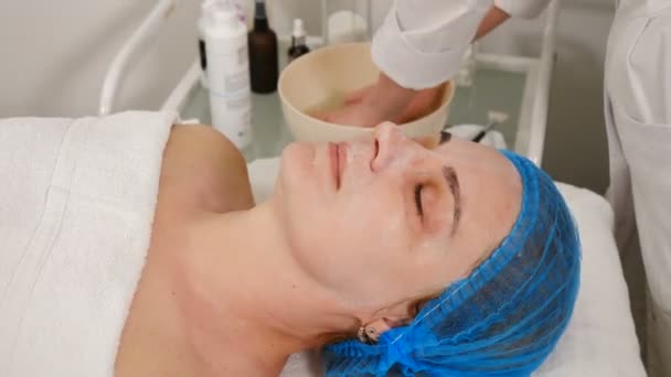 美容师医生在美容手术后擦拭和清洁女性的脸。皮肤护理和皮肤科治疗。面对翻新的概念。抗衰老程序。4k视频 — 图库视频影像