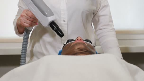 Kosmetologia sprzętu. Procedura łuszczenia twarzy węglem. Laserowe impulsy oczyszczają skórę twarzy. Leczenie kosmetologiczne sprzętu. Proces fototermolizy, rozgrzewanie skóry, laserowe obieranie węgla. Twarz — Wideo stockowe
