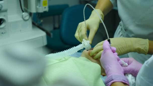 Ponořte pacientku do anestezie, holčičku s kyslíkovou maskou na chirurgickou léčbu. Anesteziolog v lékařských rukavicích připravuje dítě na operaci. Resuscitace v nemocnici. 4 k video — Stock video