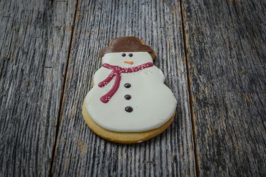 Ahşap arka plan üzerinde kardan adam kurabiye