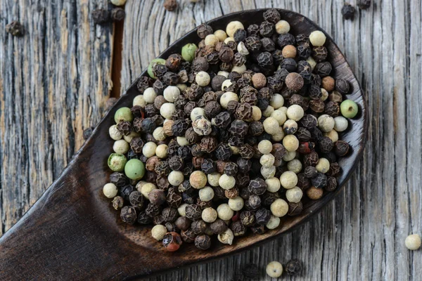 Peppercorn en una cuchara de madera — Foto de Stock