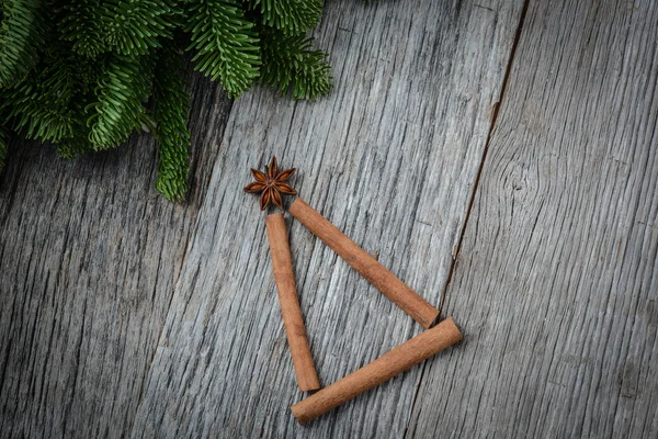 Kanelstänger formad som en julgran på trä bakgrund — Stockfoto