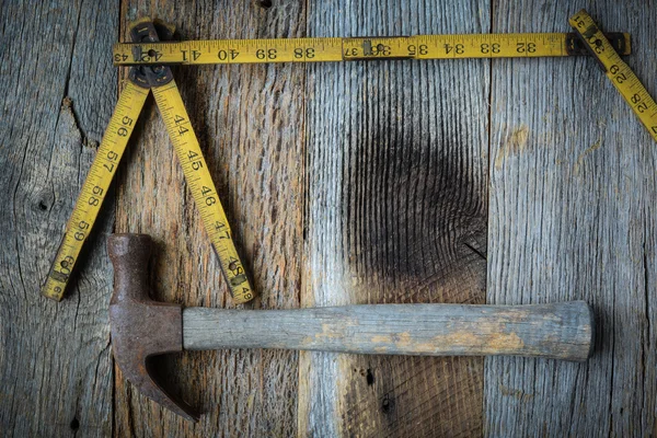 Oude lintmeter en hamer voor de bouw van rustieke houten terug — Stockfoto