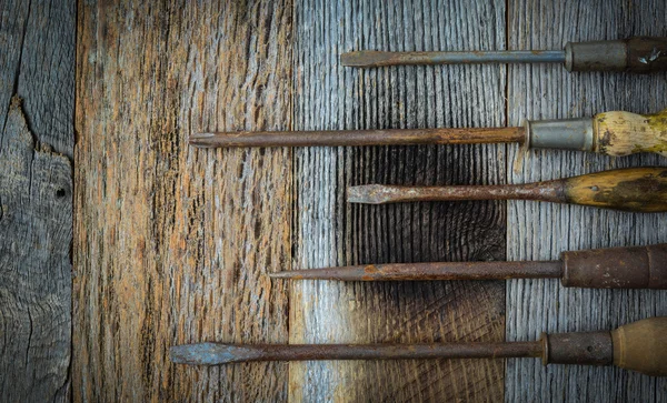 Rustika skruvmejslar på trä bakgrund — Stockfoto