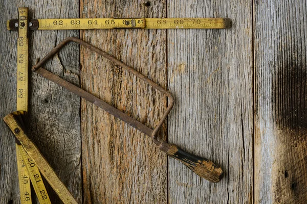 Altes Maßband und Säge für den Bau auf rustikalem Holzbackgro — Stockfoto