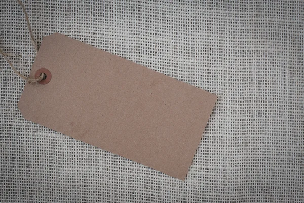 Etiqueta de papel en blanco sobre fondo de arpillera — Foto de Stock