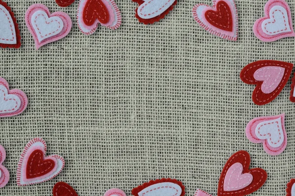 Röda hjärtan ram eller gränsen på säckväv bakgrund — Stockfoto