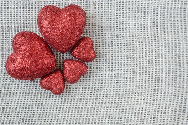 Çuval bezi arka plan üzerinde kırmızı Kalpler — Stok fotoğraf