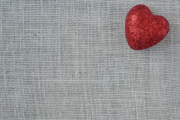 Coeur rouge sur fond de toile de jute — Photo